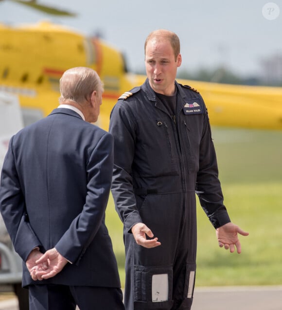 La reine Elisabeth II d'Angleterre et le prince Philip, duc d'Edimbourg visitent avec leur petit-fils prince William, duc de Cambridge, la nouvelle base East Anglian Air Ambulance à l'aéroport de Cambridge où il travaille à Cambridge, le 13 juillet 2016.