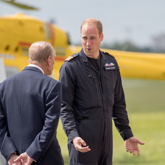 La reine Elisabeth II d'Angleterre et le prince Philip, duc d'Edimbourg visitent avec leur petit-fils prince William, duc de Cambridge, la nouvelle base East Anglian Air Ambulance à l'aéroport de Cambridge où il travaille à Cambridge, le 13 juillet 2016.