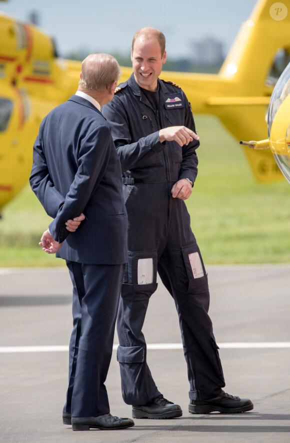 La reine Elisabeth II d'Angleterre et le prince Philip, duc d'Edimbourg visitent avec leur petit-fils prince William, duc de Cambridge, la nouvelle base East Anglian Air Ambulance à l'aéroport de Cambridge où il travaille à Cambridge, le 13 juillet 2016.