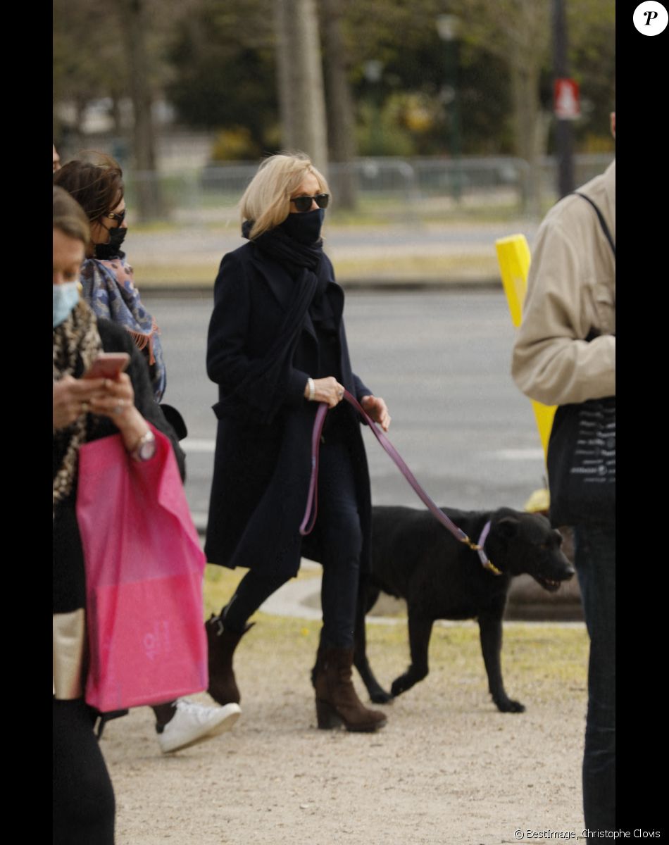 La première Dame Brigitte Macron balade son chien, Némo, et Fabienne Moszer (directrice des relations Extérieures chez Accor Arena) sur l'avenue des Champs-Élysées, à Paris, France, le 26 mars 2021. La première Dame s'est rendue à l'exposition des 20 statues du "Chat" de Philippe Geluck. © Christophe Clovis/Bestimage
