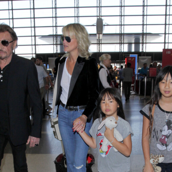 Johnny Hallyday avec sa femme Laeticia et ses enfants Jade et Joy en partance pour Paris arrivent à l'aéroport Lax de Los Angeles le 25 juin 2016.