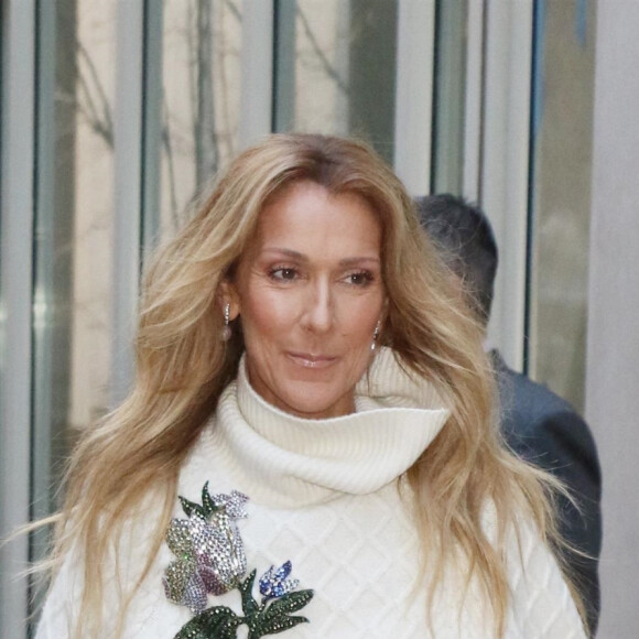 Celine Dion rayonnante et très souriante dans un ensemble pull écru et jupe bouffante fleurie salue ses fans à la sortie de son hôtel à New York, le 8 mars 2020


