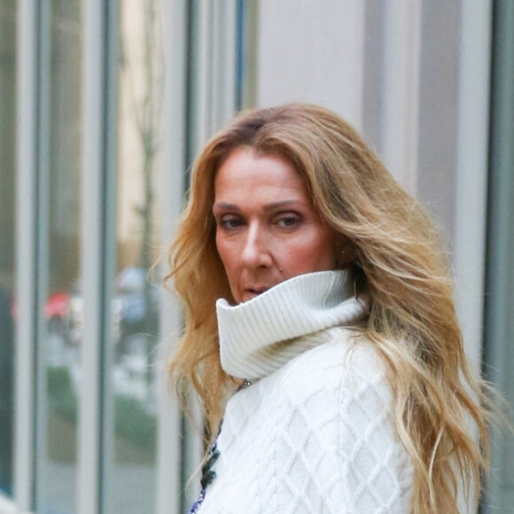 Celine Dion rayonnante et très souriante dans un ensemble pull écru et jupe bouffante fleurie salue ses fans à la sortie de son hôtel à New York, le 8 mars 2020


