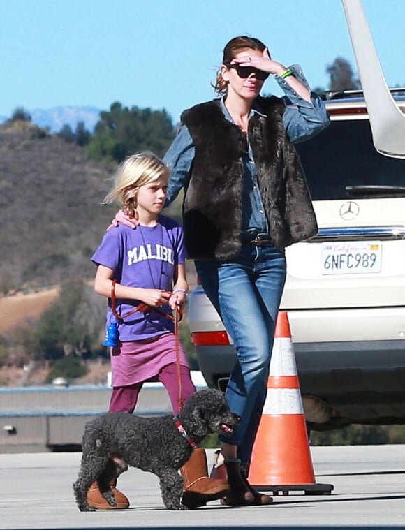 Julia Roberts et son mari Daniel Moder montent a bord d'un jet privé avec leurs enfants Phinnaeus, Hazel et Henry à Los Angeles, le 23 décembre 2013.
