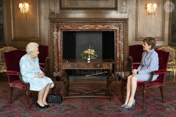 La reine Elisabeth II d'Angleterre reçoit la Première ministre d'Ecosse, Nicola Sturgeon et Alison Johnstone, présidente du Parlement écossais, au palais d'Holyroodhouse à Edimbourg, le 29 juin 2021. 