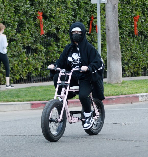 Exclusif - Billie Eilish fait du vélo électrique à Los Angeles, le 21 décembre 2020. Sur son vélo rose, la chanteuse de 19 ans était dissimulée derrière son masque de protection contre le coronavirus (Covid-19) et son hoodie. 
