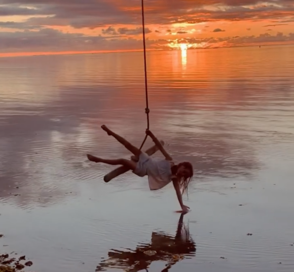 Manava, la fille d'Arthur et Mareva Galanter, se balance au-dessus de l'eau à Tahïti, en Polynésie Française. Août 2021.