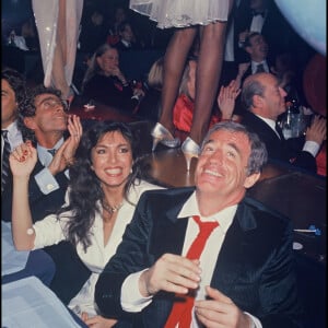 Archives - Darry Cowl, Jean-Paul Belmondo et sa compagne Carlos Sotto Mayor lors d'une soirée à "L'Alcazar" à Paris en 1985. 
