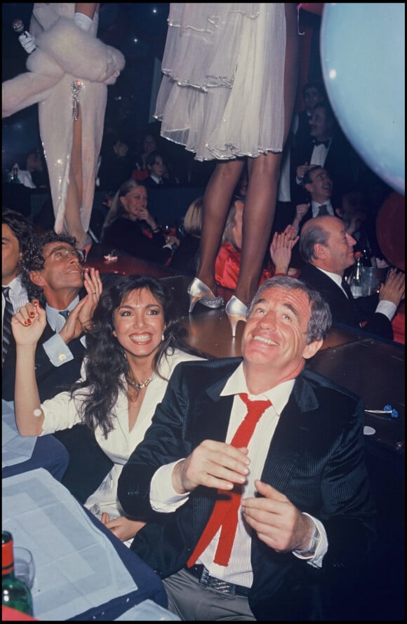 Archives - Darry Cowl, Jean-Paul Belmondo et sa compagne Carlos Sotto Mayor lors d'une soirée à "L'Alcazar" à Paris en 1985. 