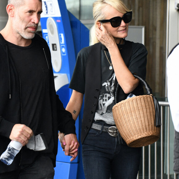 Laeticia Hallyday et ses filles Jade et Joy arrivent à l'aéroport de Roissy-Charles-de-Gaulle à Paris, le 27 juin 2021.