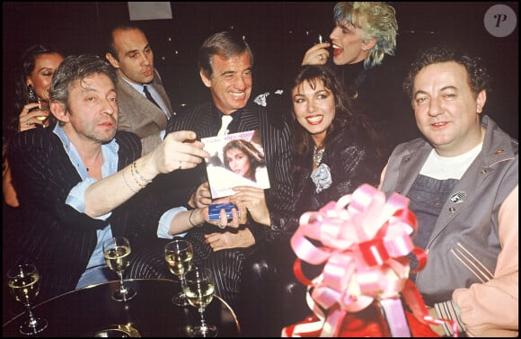 Jean-Paul Belmondo et Carlos Sotto Mayor avec Serge Gainsbourg, Guy Marchand et Coluche en soirée à Paris en 1985.