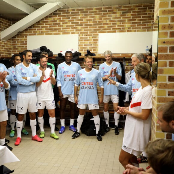 Jacques Vendroux, le manager général du Variété Club de France, La Première Dame Brigitte Macron, Karl Olive, le maire de Poissy, Christian Karembeu, Robert Pirès, Nicolas Douchez, Marcel Desailly, le président de la République Emmanuel Macron, Arsène Wenger et Laure Boulleau dans les vestiaires avant de participer au match de football caritatif, au profit de la Fondation Hôpitaux de Paris-Hôpitaux de France dans la cadre de l'opération "Pièces jaunes", présidée par la Première Dame, opposant le Variétés Club de France à une sélection de soignants du centre hospitalier intercommunal de Poissy Saint-Germain-en-Laye, au stade Léo-Lagrange à Poissy, Yvelines, France, le 14 octobre 2021. Le président de la République Emmanuel Macron sera aligné au poste de milieu défensif avec un maillot floqué du numéro 3 pour la rencontre du Variétés Club de France.