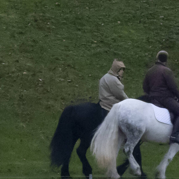 La reine Elizabeth II d'Angleterre et son majordome Terry Pendry font une promenade à cheval dans le parc du château de Windsor le 19 novembre 2020. T