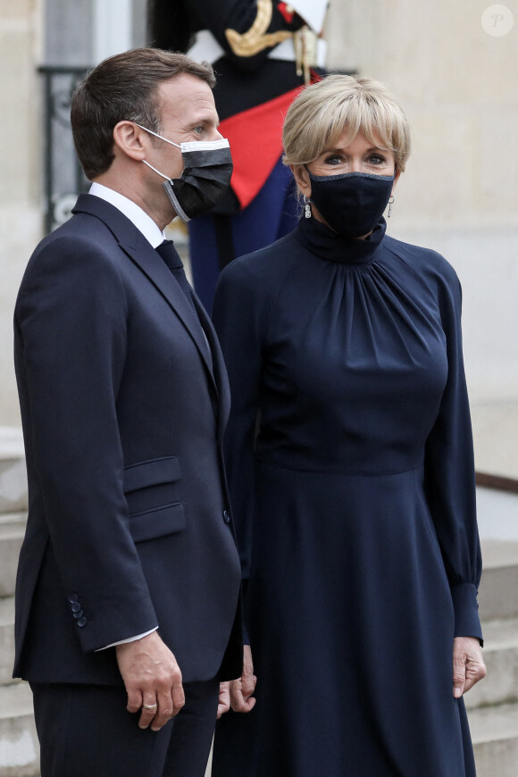 Le président de la république, Emmanuel Macron accompagné de la première dame, Brigitte Macron attendent les invités pour un dîner au Palais de l'Elysée, à l'issue d'une conférence internationale d'appui à la transition soudanaise, à Paris, le 17 mai 2021
