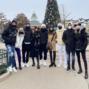 Zinédine Zidane (en jean blanc), son épouse Véronique (à sa droite), leurs quatre fils Théo, Elyaz, Enzo et Luca (de gauche à droite) et leurs chéries respectives à Disneyland Paris. Décembre 2021.