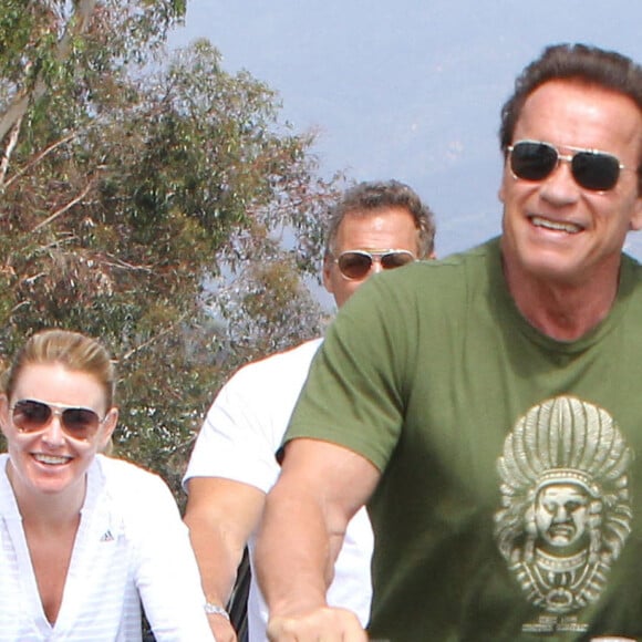 Arnold Schwarzenegger et sa compagne Heather Milligan se promènent à vélo dans les rues de Beverly Hills. Le 2 août 2015