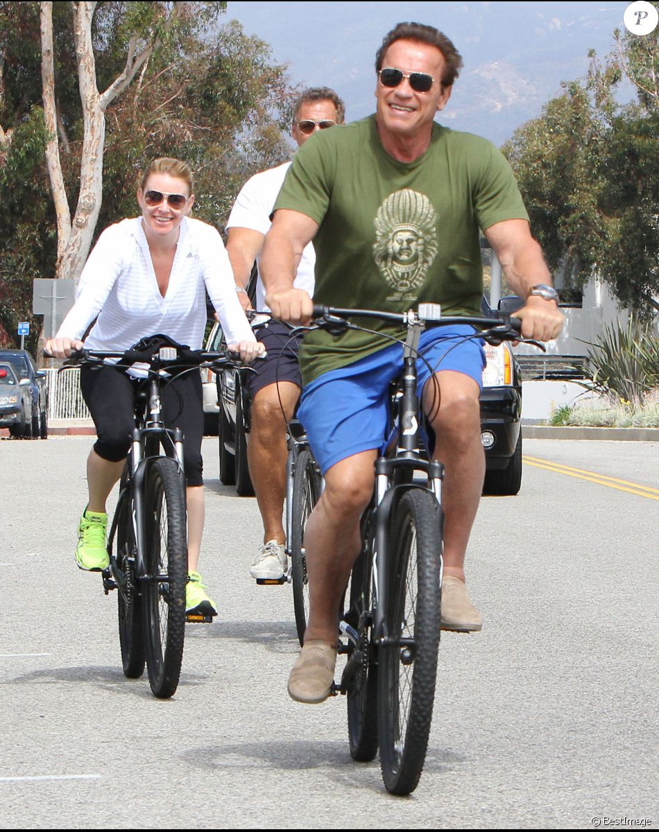 Arnold Schwarzenegger et sa compagne Heather Milligan se promènent à vélo dans les rues de Beverly Hills. Le 2 août 2015