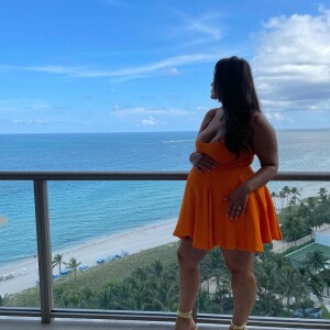 Ashley Graham enceinte pose sur le balcon de son hôtel. Le 16 août 2021.