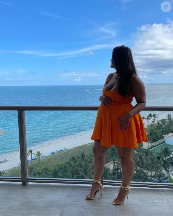 Ashley Graham enceinte pose sur le balcon de son hôtel. Le 16 août 2021.