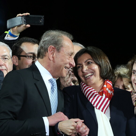 Le maire socialiste sortant Bertrand Delanoë et la nouvelle maire de Paris et la candidate socialiste Anne Hidalgo célèbrent sa victoire lors d'un rassemblement place de l'Hôtel de Ville à Paris, le 30 mars 2014, après l'annonce des résultats du second des élections municipales.