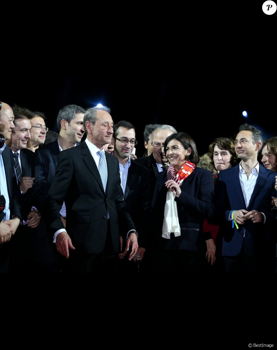 Le maire socialiste sortant Bertrand Delanoë, la nouvelle maire de Paris et la candidate socialiste Anne Hidalgo et son porte-parole Ian Brossat célèbrent sa victoire lors d'un rassemblement place de l'Hôtel de Ville à Paris, le 30 mars 2014, après l'annonce des résultats du second des élections municipales. Anne Hidalgo est la première femme élue maire de Paris.