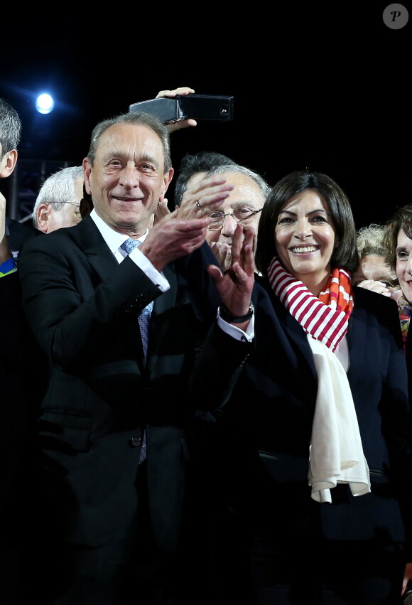 Le maire socialiste sortant Bertrand Delanoë et la nouvelle maire de Paris et la candidate socialiste Anne Hidalgo célèbrent sa victoire lors d'un rassemblement place de l'Hôtel de Ville à Paris, le 30 mars 2014, après l'annonce des résultats du second des élections municipales.