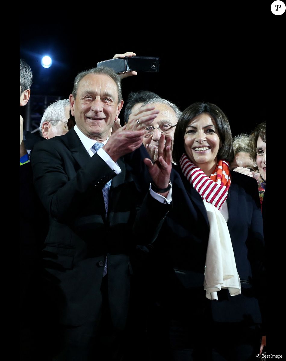 Le maire socialiste sortant Bertrand Delanoë et la nouvelle maire de Paris et la candidate socialiste Anne Hidalgo célèbrent sa victoire lors d'un rassemblement place de l'Hôtel de Ville à Paris, le 30 mars 2014, après l'annonce des résultats du second des élections municipales.