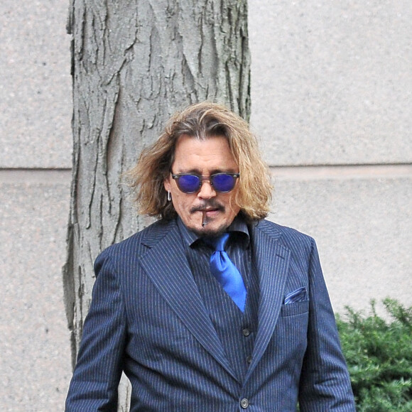 Johnny Depp et ses avocats sortent de leur hôtel à McLean, Virginie, Etats-Unis, le 13 avril 2022, pour se rendre au tribunal pour le troisième jour du procès en diffamation. Johnny Depp en profite pour saluer ses fans avant de monter dans sa voiture.