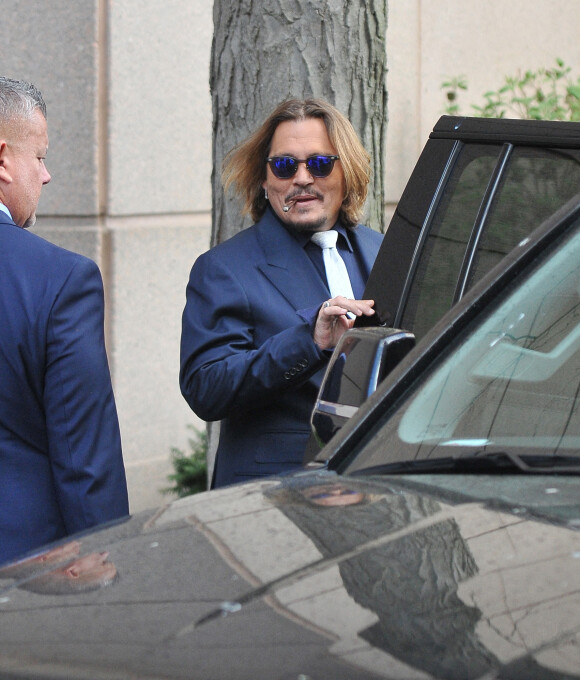 Johnny Depp et ses avocats sortent de leur hôtel à McLean, Virginie, Etats-Unis, le 12 avril 2022, pour se rendre au tribunal pour le deuxième jour du procès en diffamation. Johnny Depp en profite pour saluer ses fans avant de monter dans sa voiture.