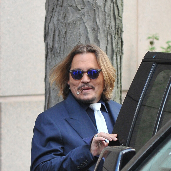 Johnny Depp et ses avocats sortent de leur hôtel à McLean, Virginie, Etats-Unis, le 12 avril 2022, pour se rendre au tribunal pour le deuxième jour du procès en diffamation. Johnny Depp en profite pour saluer ses fans avant de monter dans sa voiture.
