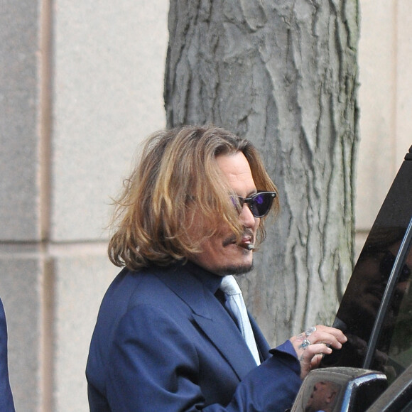 Johnny Depp et ses avocats sortent de leur hôtel à McLean, Virginie, Etats-Unis, le 12 avril 2022, pour se rendre au tribunal pour le deuxième jour du procès en diffamation. Johnny Depp en profite pour saluer ses fans avant de monter dans sa voiture.