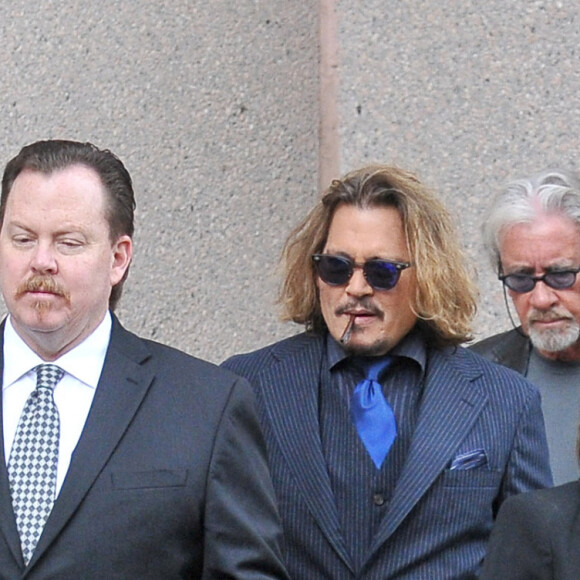 Johnny Depp et ses avocats sortent de leur hôtel à McLean, Virginie, Etats-Unis, le 13 avril 2022, pour se rendre au tribunal pour le troisième jour du procès en diffamation. Johnny Depp en profite pour saluer ses fans avant de monter dans sa voiture.