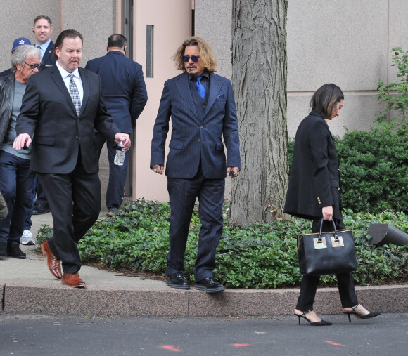 Johnny Depp et ses avocats sortent de leur hôtel à McLean, Virginie, Etats-Unis, le 13 avril 2022, pour se rendre au tribunal pour le troisième jour du procès en diffamation. Johnny Depp en profite pour saluer ses fans avant de monter dans sa voiture. 