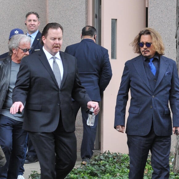 Johnny Depp et ses avocats sortent de leur hôtel à McLean, Virginie, Etats-Unis, le 13 avril 2022, pour se rendre au tribunal pour le troisième jour du procès en diffamation. Johnny Depp en profite pour saluer ses fans avant de monter dans sa voiture. 