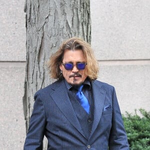 Johnny Depp et ses avocats sortent de leur hôtel à McLean, Virginie, Etats-Unis, le 13 avril 2022, pour se rendre au tribunal pour le troisième jour du procès en diffamation. Johnny Depp en profite pour saluer ses fans avant de monter dans sa voiture. 