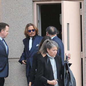 Johnny Depp et ses avocats sortent de leur hôtel à McLean, Virginie, Etats-Unis, le 12 avril 2022, pour se rendre au tribunal pour le deuxième jour du procès en diffamation. Johnny Depp en profite pour saluer ses fans avant de monter dans sa voiture. 