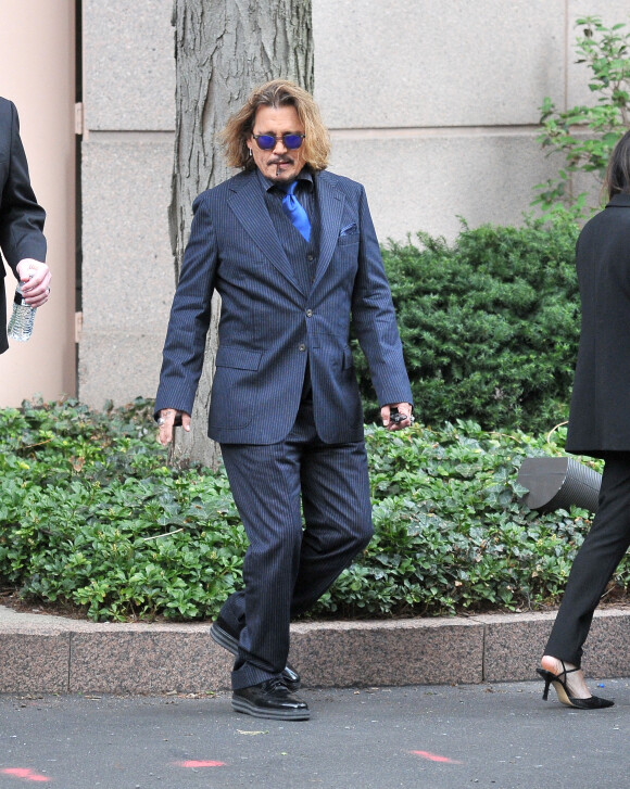Johnny Depp et ses avocats sortent de leur hôtel à McLean, Virginie, Etats-Unis, le 13 avril 2022, pour se rendre au tribunal pour le troisième jour du procès en diffamation. Johnny Depp en profite pour saluer ses fans avant de monter dans sa voiture. 