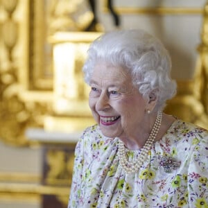 La reine Elizabeth II d'Angleterre parcourt l'exposition d'objets de la société d'artisanat britannique Halcyon Days, pour marquer son jubilé de platine, au château de Windsor, le 23 mars 2022.