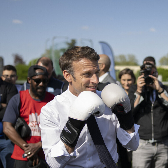 Le président de la République française et candidat du parti centriste La République en marche (LREM) à la réélection, Emmanuel Macron, s'essaye à la boxe lors d'une visite de campagne dans la banlieue nord de Paris à Saint-Denis, Seine Saint-Denis, France, le 21 avril 2022.