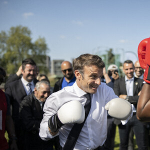 Le président de la République française et candidat du parti centriste La République en marche (LREM) à la réélection, Emmanuel Macron, s'essaye à la boxe lors d'une visite de campagne dans la banlieue nord de Paris à Saint-Denis, Seine Saint-Denis, France, le 21 avril 2022.