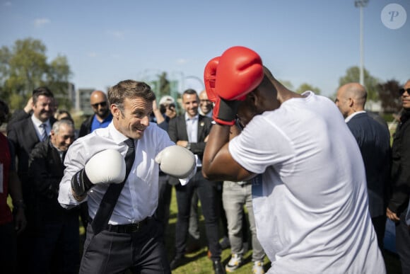 Le président de la République française et candidat du parti centriste La République en marche (LREM) à la réélection, Emmanuel Macron, s'essaye à la boxe lors d'une visite de campagne dans la banlieue nord de Paris à Saint-Denis, Seine Saint-Denis, France, le 21 avril 2022.
