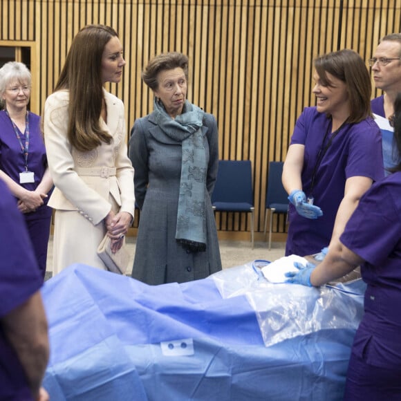 Catherine (Kate) Middleton, duchesse de Cambridge, et la princesse Anne assistent à une démonstration de simulation d'opération césarienne d'urgence au Royal College of Obstetricians & Gynaecologists à Londres, le 27 avril 2022. 