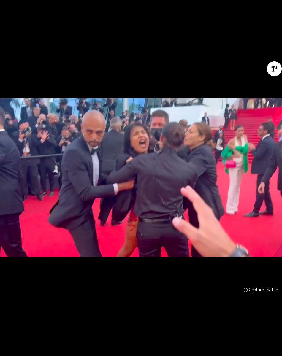 Une femme à moitié nue s'infiltre sur le tapis rouge lors de la montée des marches de "Trois milles ans à t'attendre"