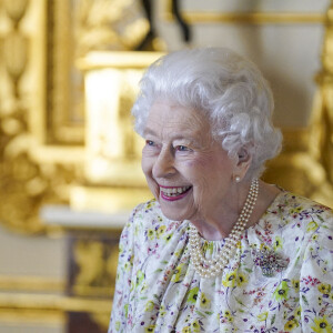 La reine Elizabeth II d'Angleterre parcourt l'exposition d'objets de la société d'artisanat britannique Halcyon Days, pour marquer son jubilé de platine, au château de Windsor, le 23 mars 2022.