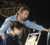 En France, à Paris, Serge Gainsbourg chez lui avec sa fille Charlotte dans son hotel particulier de la rue de Verneuil, posant au milieu de son bric-à-brac où il entasse des objets hétéroclites en mai 1985. © Michel Marizy via Bestimage
