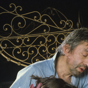 En France, à Paris, Serge Gainsbourg chez lui avec sa fille Charlotte dans son hotel particulier de la rue de Verneuil, posant au milieu de son bric-à-brac où il entasse des objets hétéroclites en mai 1985. © Michel Marizy via Bestimage