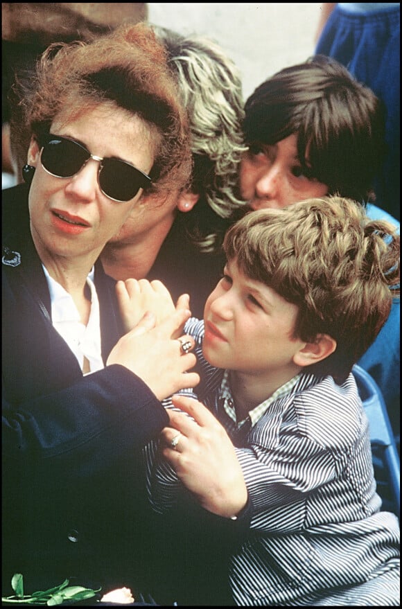 Véronique Kantor et ses enfants Romain et Marius lors de l'enterrement de Coluche en 1986