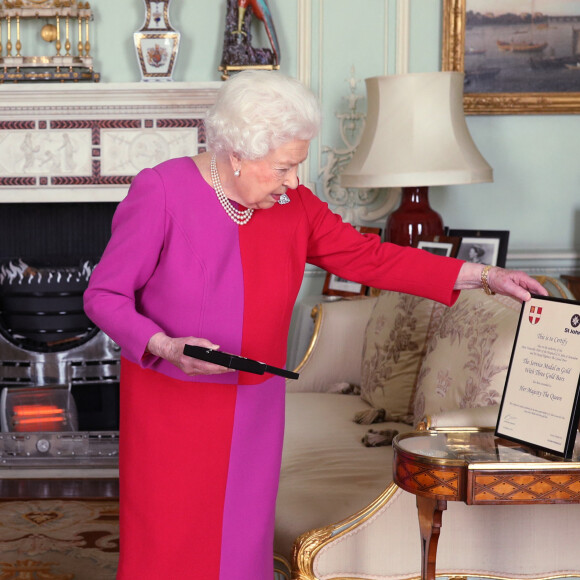La reine Elizabeth II d'Angleterre se voit remettre la première Médaille d'Ordre en Or par le professeur Mark Compton lors d'une audience au palais de Buckingham à Londres. Le 11 mars 2020