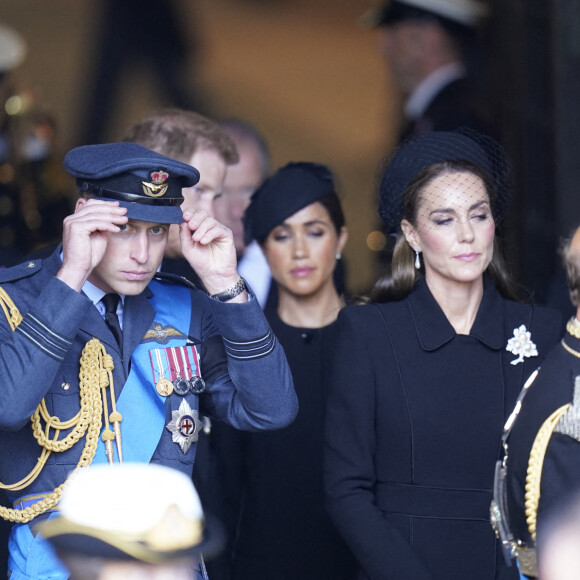 Meghan Markle au côté du prince Harry, son époux, et derrière le prince William, prince de Galles, et Kate Middleton, princesse de Galles lors de la procession cérémonielle du cercueil de la reine Elisabeth II du palais de Buckingham à Westminster Hall à Londres. Quelle place lui sera accordée lors des funérailles nationales ?