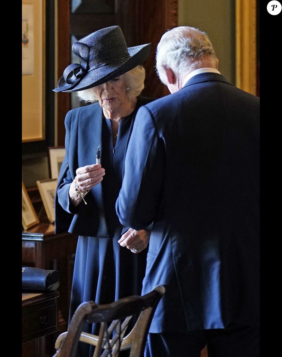 Camilla Parker Bowles, reine consort d'Angleterre, examine le stylo défectueux avec lequel le roi Charles III a signé le livre d'or au Hillsborough Castle le 13 septembre 2022.